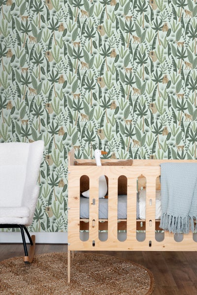 Kinderzimmer mit Dschungeltapete, Gitterbett und Schaukelstuhl