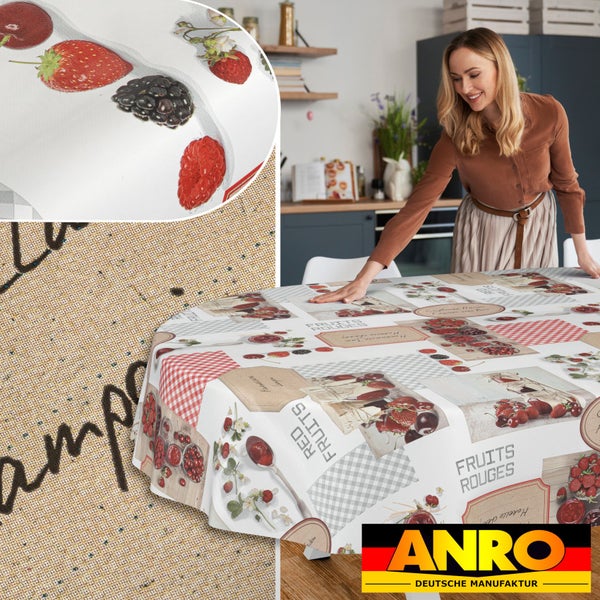Rundes Wachstuch mit Beeren-Motiven und Karomuster. Eine Frau breitet die Tischdecke in einer modernen Küche aus. ANRO Logo.