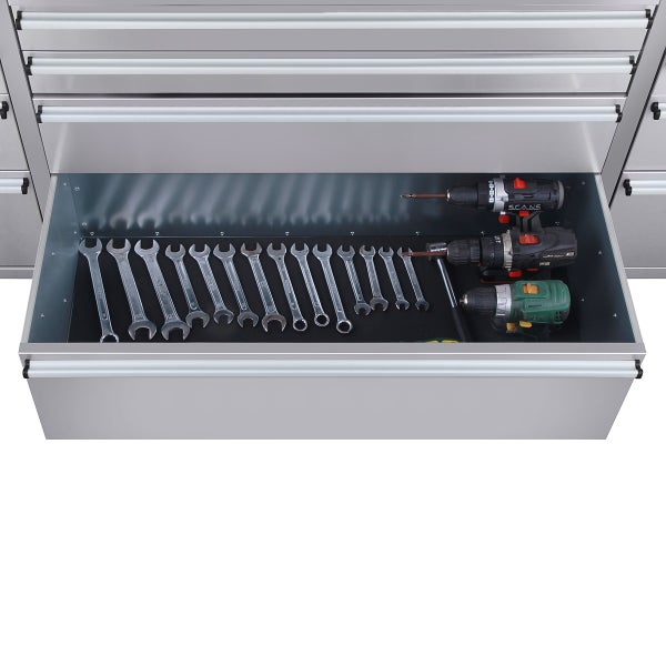 Geöffnete Werkzeugschublade mit Schraubenschlüsseln und Akkubohrern