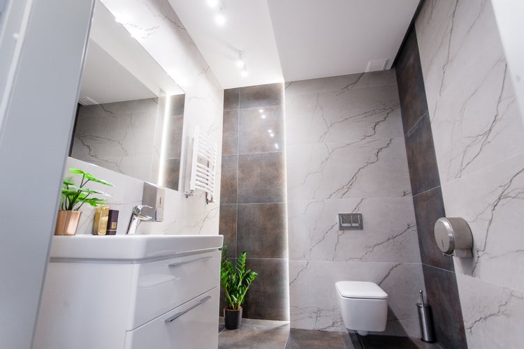 Modernes Badezimmer mit Waschbeckenunterschrank, Toilette und Fliesen