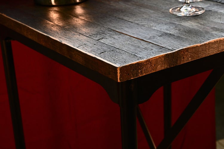 Detailansicht eines Tisches mit einer Tischplatte aus Holz und einem Untergestell aus Metall