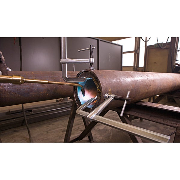 Metallrohr wird mit Brenner und Schraubzwingen bearbeitet
