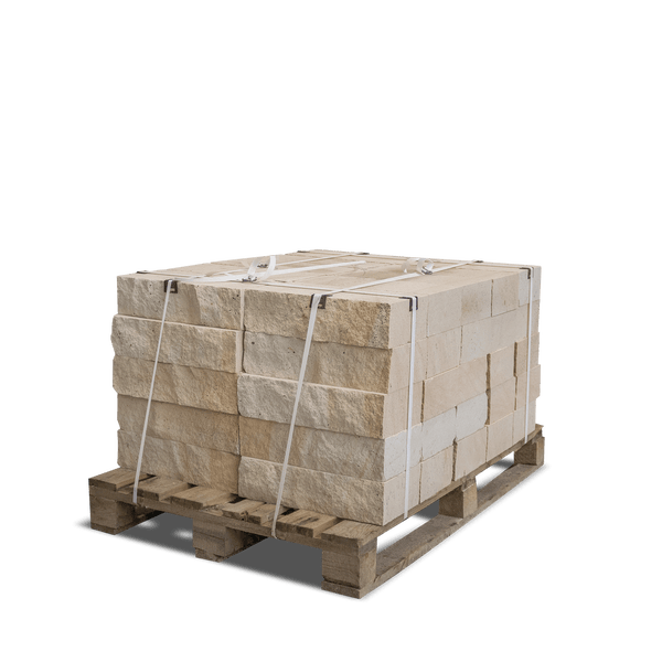 Beige Natursteine gestapelt auf einer Holzpalette, mit Umreifungsbändern gesichert.