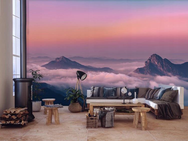 Wohnzimmer mit Ofen, Holzscheiten, Holzmöbeln und einer Fototapete mit Bergmotiv.