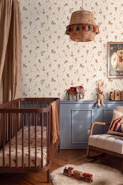 Kinderzimmer mit Zirkus Motiv Tapete in einem warmen Raum mit dunklem Holzkinderbett, Schaukelstuhl und Zirkusdekorationen.