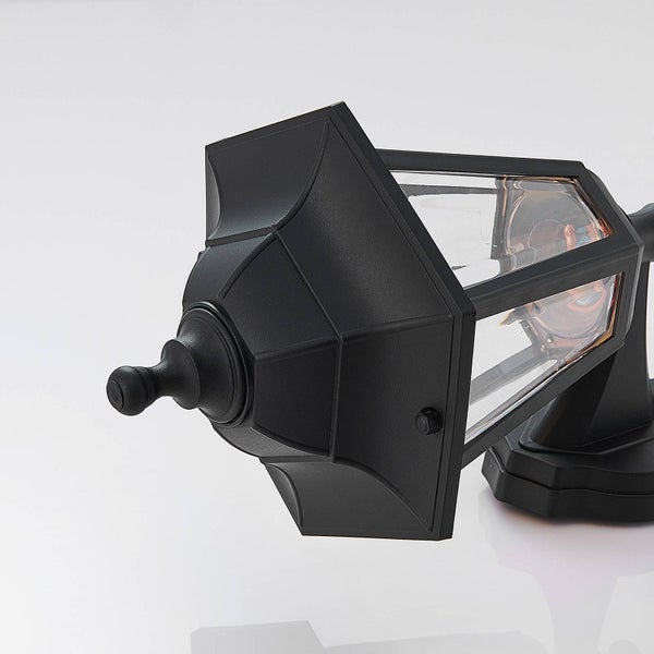 Schwarze Außenwandleuchte in Laternenform mit Glaseinsätzen und dekorativer Spitze.