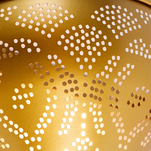 Detailaufnahme einer goldenen Lampe mit Lochmuster