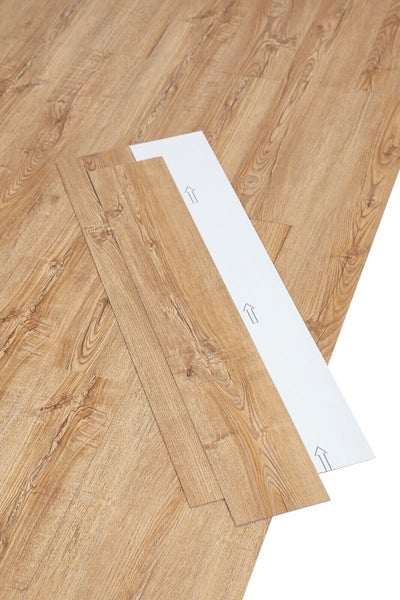 Selbstklebender Vinylboden in Holzoptik, Planken mit Schutzfolie und Verlegepfeilen.