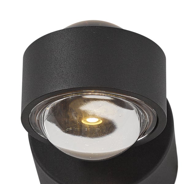 Wandleuchte mit runder Glaslinse und schwarzem Gehäuse.