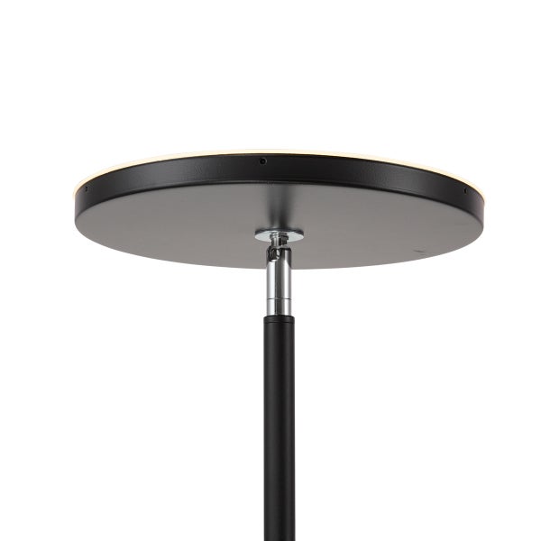 Detailansicht einer modernen Stehleuchte mit flachem, schwarzem Rundkopf und verstellbarem Gelenk aus Chrom.