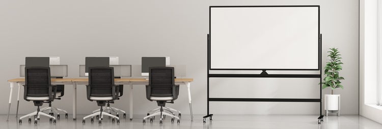 Modernes Büro mit drei Schreibtischen aus Holz, schwarzen ergonomischen Bürostühlen und einem großen fahrbaren Whiteboard auf einem Gestell.