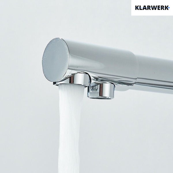 Klarwerk Logo. Verchromte Armatur mit zwei Ausläufen, Wasser fließt aus einer Düse.
