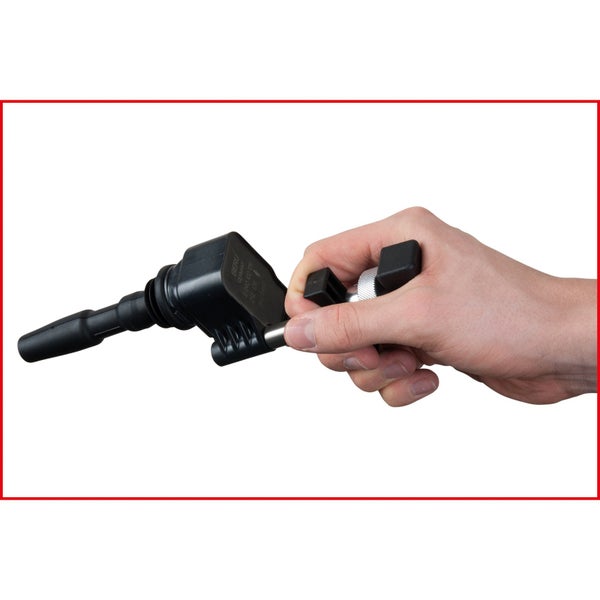 Zündspule mit Abzieher in einer Hand