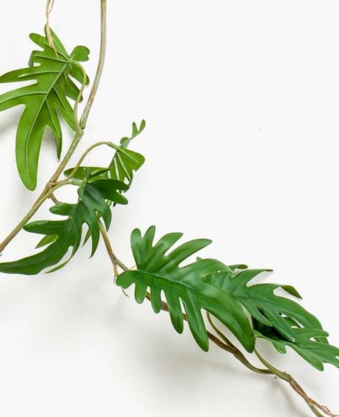 Künstlicher Philodendron-Zweig mit tief eingeschnittenen Blättern.