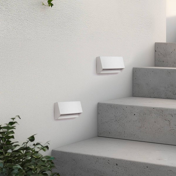 Zwei moderne weiße LED-Wandleuchten zur Treppenbeleuchtung an einer strukturierten Wand neben Betonstufen.