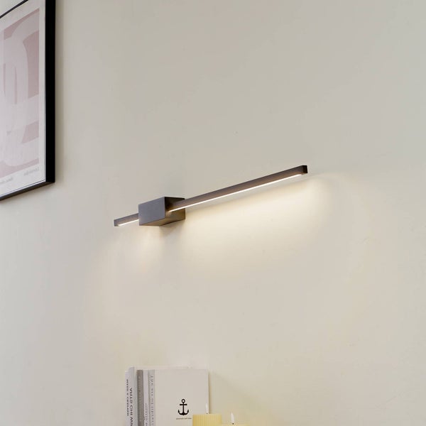Moderne schwarze lineare LED-Wandleuchte aus Metall mit warmweißem Lichtschein nach unten.