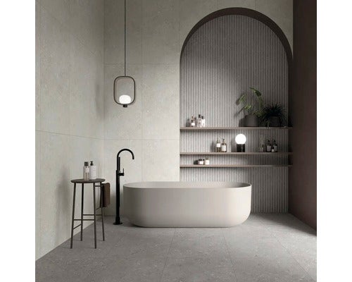 Modernes Badezimmer mit freistehender Badewanne, Hocker, Wandregalen und großformatigen Fliesen.
