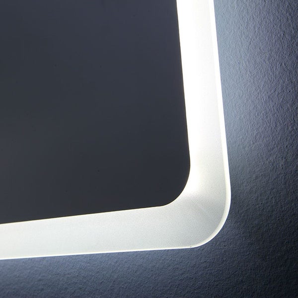 Detailansicht eines Badezimmerspiegels mit abgerundeter Ecke und integrierter LED-Beleuchtung an einer strukturierten Wand.
