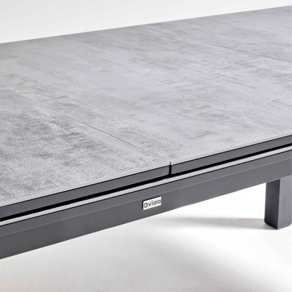 Detailansicht eines ausziehbaren Oviala Gartentischs mit grauer strukturierter Platte, anthrazitfarbenem Aluminiumrahmen und Oviala Logo.