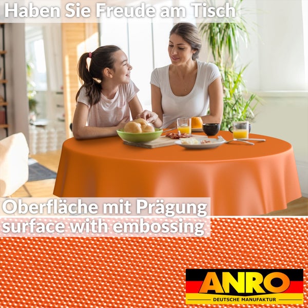 Mutter und Tochter am runden Tisch mit orangefarbener, geprägter Tischdecke beim Frühstück. Detailansicht der Struktur. ANRO Logo.