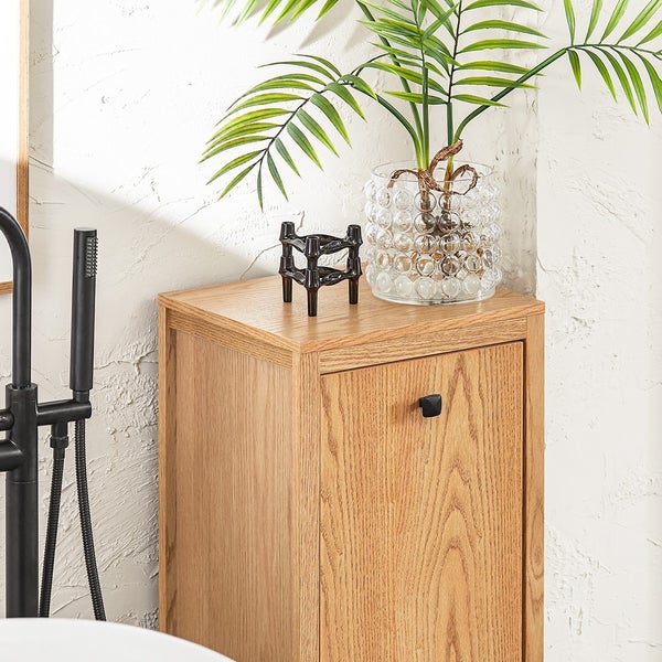 Badezimmer Szene mit Waschtischunterschrank, Kerzenständer, Glasvase und Palme.