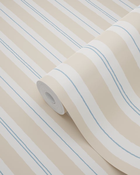 Zimmer mit gestreifter Tapete und einem Jungen, der in die Kamera zeigt.