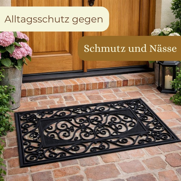 Schwarze Fußmatte mit Muster vor einer Haustür