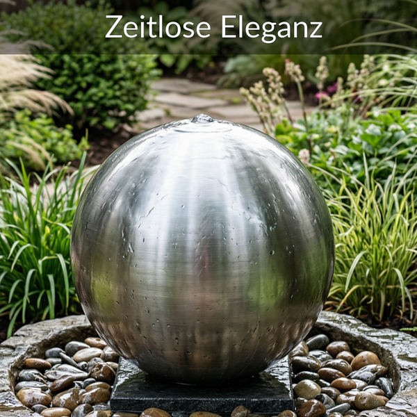 Kugelbrunnen aus Edelstahl in einem Garten mit Kieselsteinen und Pflanzen.