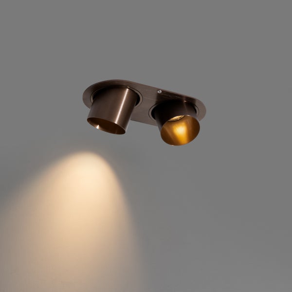 Zweiflammiger Deckenspot aus Metall in Bronze-Optik mit ovaler Basis und verstellbaren Strahlern.