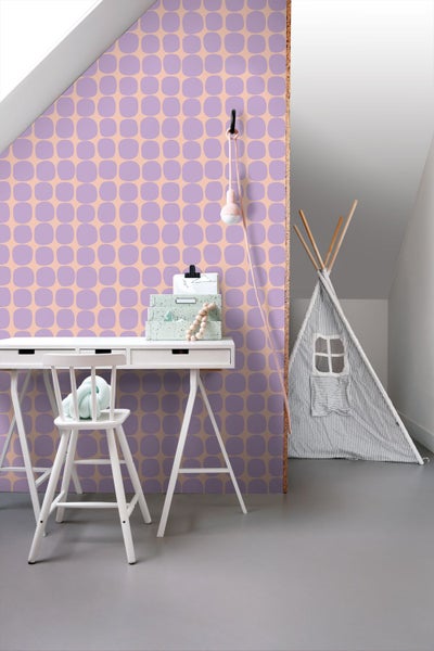 Heller moderner Raum mit geometrisch gemusterter Tapete, weißem Schreibtisch mit Stuhl und einem Tipi Spielzelt aus Stoff.