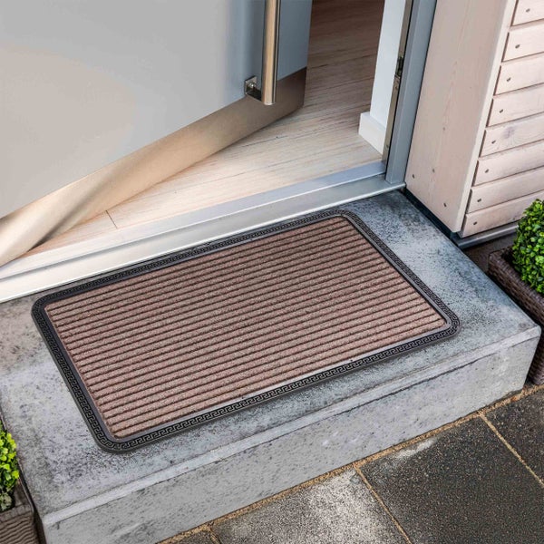 Fußmatte mit Muster vor einer geöffneten Tür auf einer Treppe