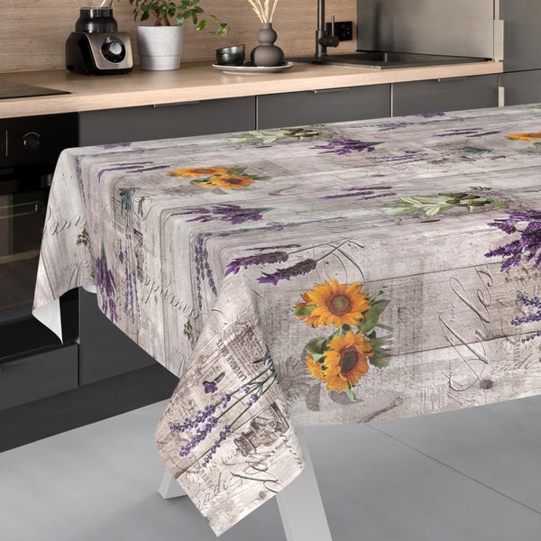 Wachstuch-Tischdecke mit Sonnenblumen- und Lavendelmotiv auf Holzoptik in einer modernen Küche.