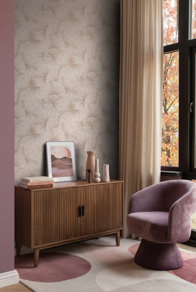 Vliestapete mit fächerförmigem Blattmuster in einem modern eingerichteten Wohnzimmer mit Sideboard und Sessel.