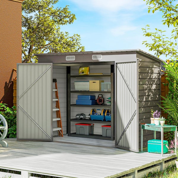 Helles Gerätehaus aus Metall mit geöffneten Doppeltüren auf einer Holzterrasse. Das organisierte Innere zeigt Regale mit Werkzeugen und Boxen.