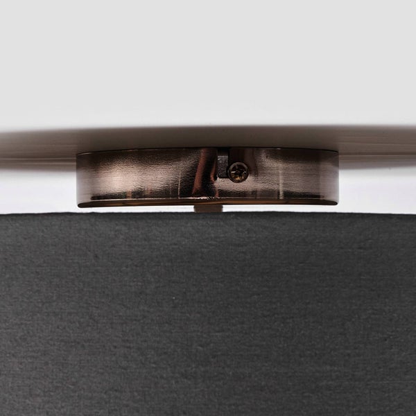 Detailansicht einer Deckenleuchte mit metallischer Befestigung und einem Lampenschirm aus grauem Stoff.