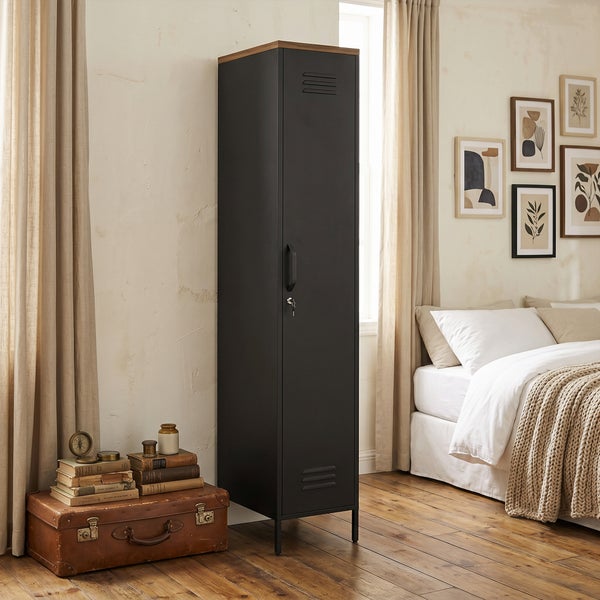 Schmaler Metallspind mit Holzelement oben, abschließbare Tür, in einem gemütlich eingerichteten Schlafzimmer mit Vintage Accessoires.