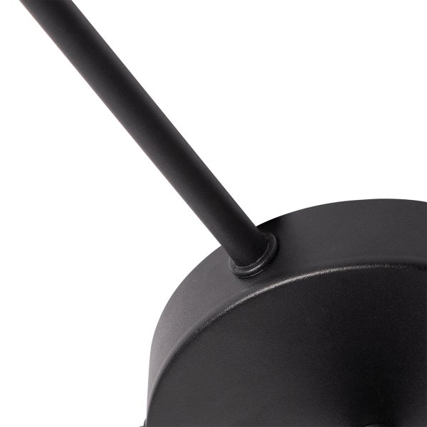 Detailaufnahme der runden Halterung und des Arms einer schwarzen Leuchte aus Metall.