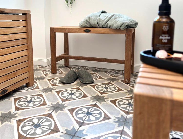 Badezimmer Szene mit Holzbank, Bademantel, Hausschuhen und dekorativen Fliesen