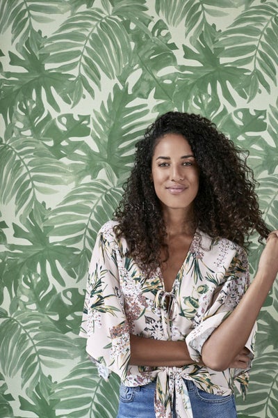 Frau vor einer grünen Blättertapete