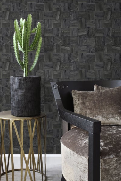 Dekoratives Wohnzimmer mit Kaktus, Beistelltisch und Sessel vor einer Wand mit Holzfliesenmuster