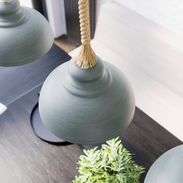 Moderne Pendelleuchte mit mattgrauem, glockenförmigem Schirm und Seilaufhängung aus Naturfasern über einem dunklen Holztisch.