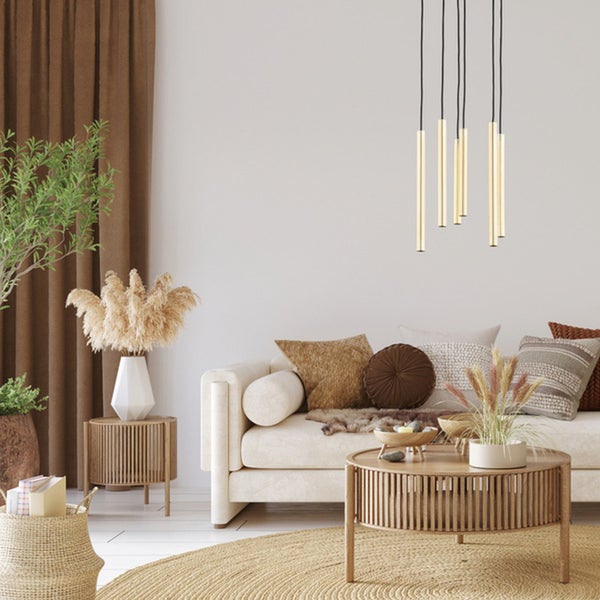 Ein helles Wohnzimmer mit einem beigen Sofa, einer modernen Pendelleuchte und einem runden Couchtisch aus Holz im skandinavischen Einrichtungsstil.