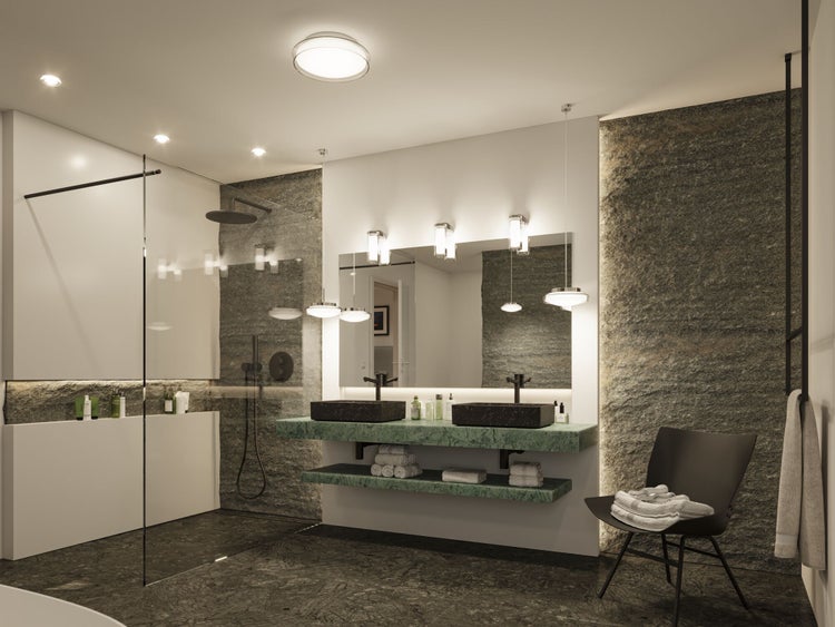 Modernes, geräumiges Badezimmer mit Doppelwaschtisch aus grünem Marmor, Steinwänden, begehbarer Dusche und heller Beleuchtung.