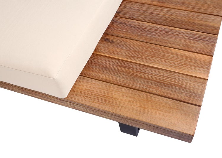 Nahaufnahme einer Gartenlounge mit Holzlatten und einer hellen Polsterauflage.