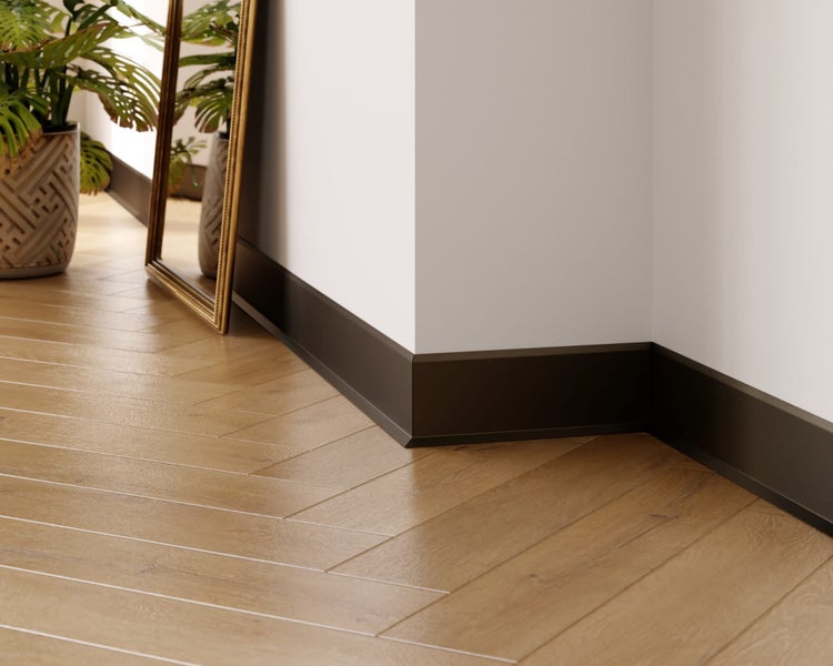 Innenaufnahme einer Sockelleiste an einer Ecke mit Holzboden