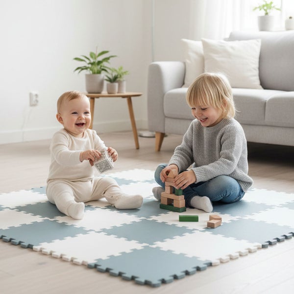 Kleinkinder spielen auf einer Schaumstoff-Puzzlematte in einem hellen, organisierten Wohnzimmer.