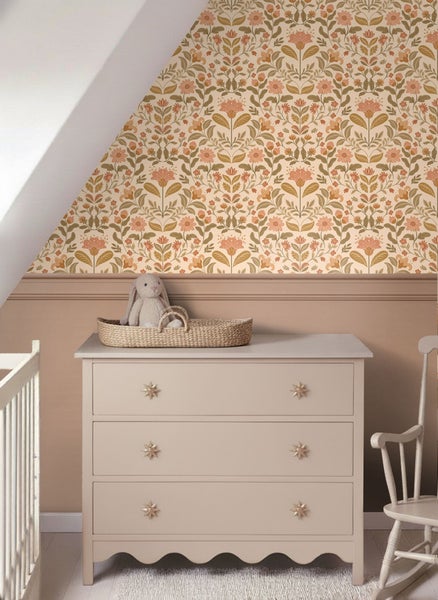 Kinderzimmer mit floral gemusterter Tapete, Kommode mit Sternknöpfen und Spielzeugkorb