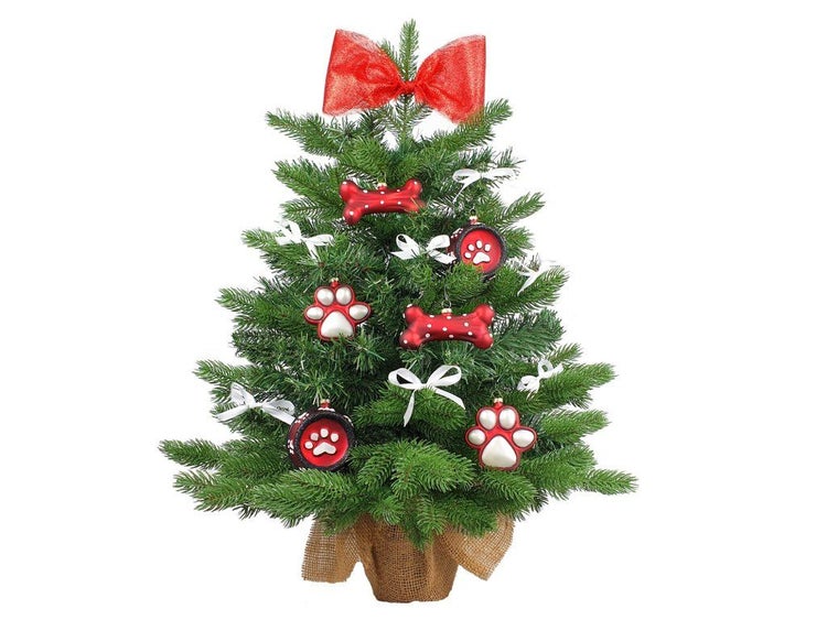 Künstlicher Weihnachtsbaum in Jutesack mit weihnachtlichem Haustierbaumschmuck in Form von Knochen und Pfotenabdrücken sowie roter Schleife.