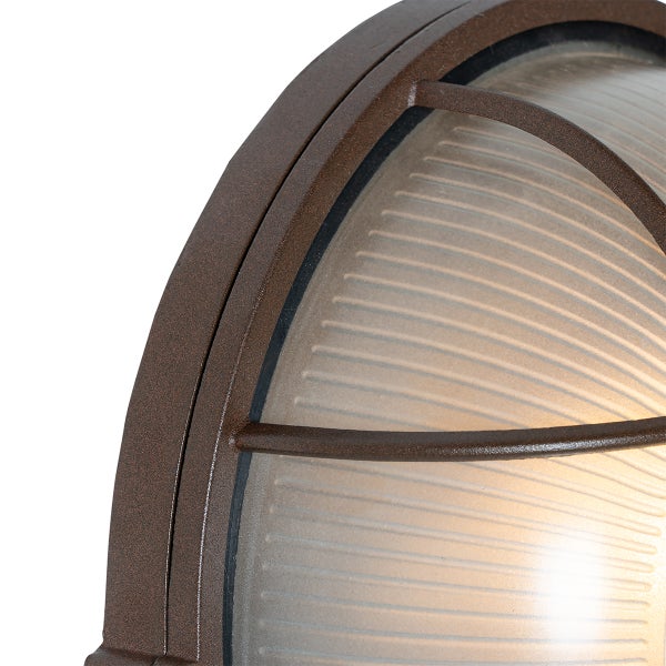 Detailaufnahme einer Außenwandleuchte mit braunem Metallrahmen und geripptem Glas.