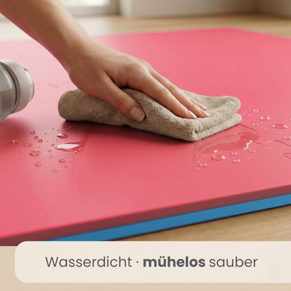Eine Hand wischt mit einem Tuch Wassertropfen von einer wasserdichten Matte ab, was die einfache Reinigung veranschaulicht.